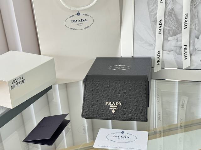 Prada 新款上线了 按扣式开合短夹， 男女通用，型号1Mv021， 颜色如图所示 一个钞票隔层，四个卡槽，两个内部口袋，另外还有一个拉链式口袋 十字纹牛皮制