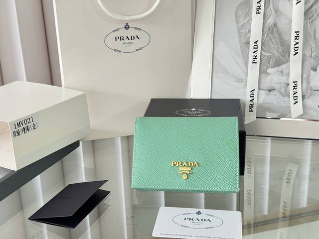 Prada 新款上线了 按扣式开合短夹， 男女通用，型号1Mv021， 颜色如图所示 一个钞票隔层，四个卡槽，两个内部口袋，另外还有一个拉链式口袋 十字纹牛皮制