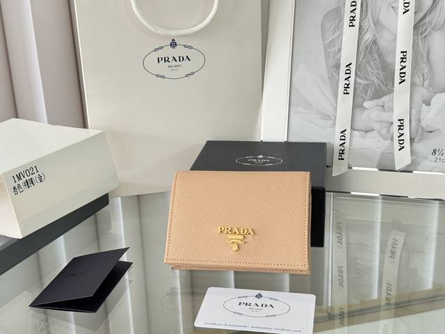 Prada 新款上线了 按扣式开合短夹， 男女通用，型号1Mv021， 颜色如图所示 一个钞票隔层，四个卡槽，两个内部口袋，另外还有一个拉链式口袋 十字纹牛皮制
