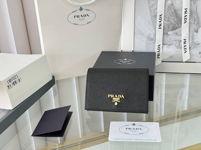 Prada 新款上线了 按扣式开合短夹， 男女通用，型号1Mv021， 颜色如图所示 一个钞票隔层，四个卡槽，两个内部口袋，另外还有一个拉链式口袋 十字纹牛皮制