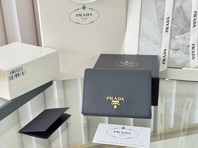 Prada 新款上线了 按扣式开合短夹， 男女通用，型号1Mv021， 颜色如图所示 一个钞票隔层，四个卡槽，两个内部口袋，另外还有一个拉链式口袋 十字纹牛皮制