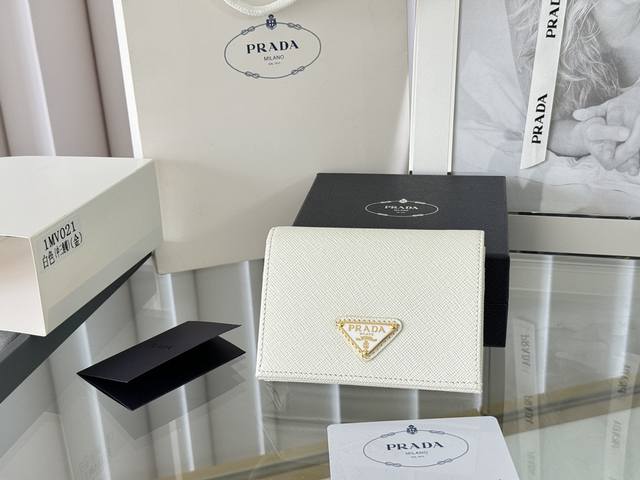 Prada 新款上线了 按扣式开合短夹， 男女通用，型号1Mv021， 颜色如图所示 一个钞票隔层，四个卡槽，两个内部口袋，另外还有一个拉链式口袋 十字纹牛皮制
