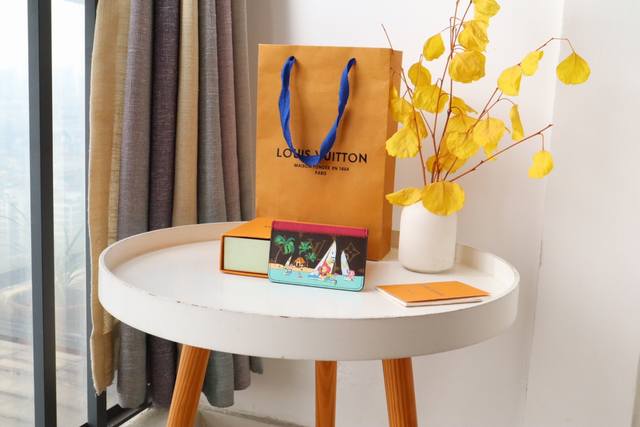 圣诞系列82853卡片夹 本款 Monogram 帆布卡夹印有活泼可爱的品牌吉祥物 Vivienne，生动细致地描绘她与朋友在热带海滩附近乘船玩耍的场景。夹层内