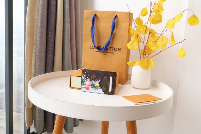 圣诞系列82582卡夹 庆祝运动乐趣的限量版“卡盒波尔图卡罗米”。用单幅画布缝制，印制了路易 维顿的受欢迎吉祥物“维安娜”和她的朋友在滑冰上探索山区的形象。可存