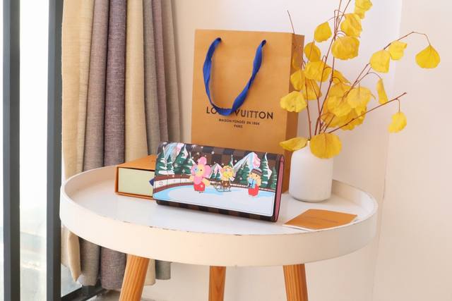 圣诞系列40722 长款钱包 由达米埃帆布制作的“Portofouille Sara Nm”。在翼上，以充满乐趣的印刷品装饰了豪宅的人气吉祥物“Vivienne