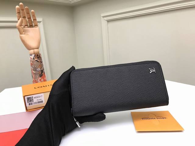 顶级原单 M30317 黑色zippy Vertical 钱夹将功能细节隐藏于流畅线条之下。经典 Taga 皮革柔软且耐用，银色金属 Lv 标识象征路易威登家族