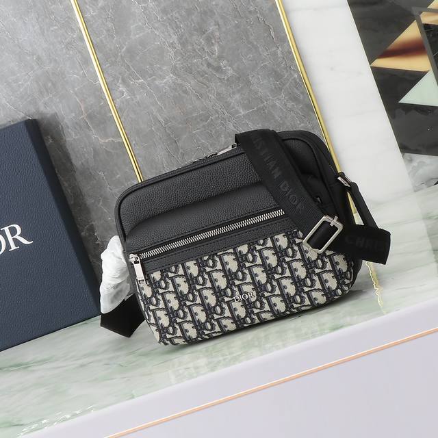 这款 Rider 2.0 拉链式信使包实用而精巧,是日常生活的理想单品。采用米色和黑色 Oblique 印花面料精心制作,饰以黑色粒面牛皮革细节,正面点缀以 D 这款 Rider 2.0 拉链式信使包实用而精巧,是日常生活的理想单品。采用米色和黑色 Oblique 印花面料精心制作,饰以黑色粒面牛皮革细节,正面点缀以 D