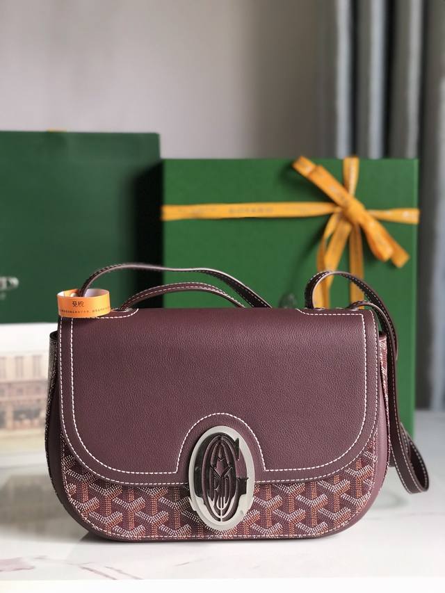 Goyard 233 Lll 既保留了经典版的标志性元素，如醒目的金属logo扣、整面的皮革翻盖和独特的曲线外形，同时赋予这款包袋更轻盈的流线设计以及更摩登的当