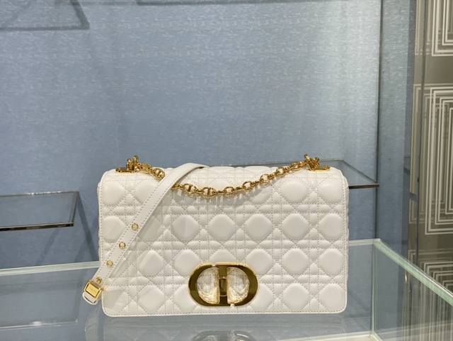 Dior Caro 手袋采牛皮革精心制作，饰以标志性的藤格纹针脚。材质柔软，翻盖饰以复古金色饰面金属“Cd”扣环，灵感源自 Christian Dior 香水瓶