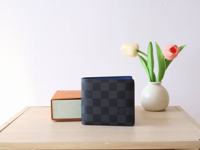 N00091芯片版 独家实拍！Slender Wallet由经典的damier Graphite涂层帆布制成，内衬蓝色牛皮，为灰色棋盘增添了现代感。这款小巧的钱