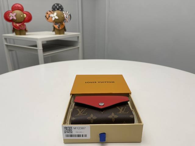 顶级原单 M12387红从路易 维顿的档案中获得灵感，以本季特有的全新颜色更新了“Portouille Victorine”。在签名单体画布上配有银色快门按钮，