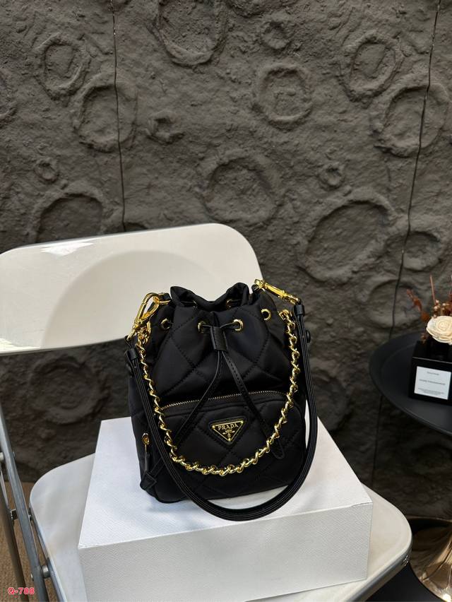 配折叠盒 普拉达 Prada菱格水桶包 勾勒出高级品味的光辉，展现着低调与奢华尼龙材质的面料则为包包带来了时尚的质感～抽绳束口的设计不仅方便实用，精致而时尚，简