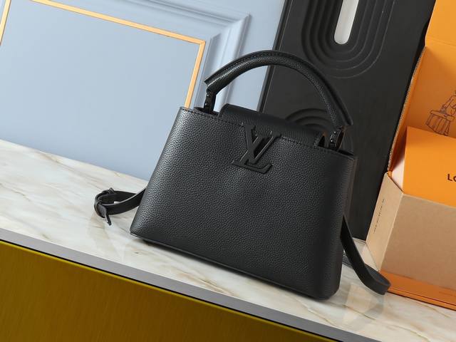 升级原版 M25255 M25256 本款 Capucines Bb 手袋为哑光 Taurillon 牛皮革搭配金属件，令经典设计展露利落风范。翻盖提供外置或内