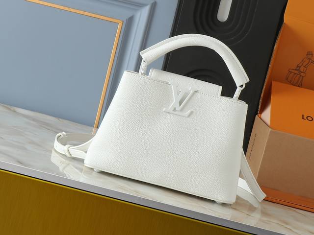 升级原版 M25255 M25256 本款 Capucines Bb 手袋为哑光 Taurillon 牛皮革搭配金属件，令经典设计展露利落风范。翻盖提供外置或内