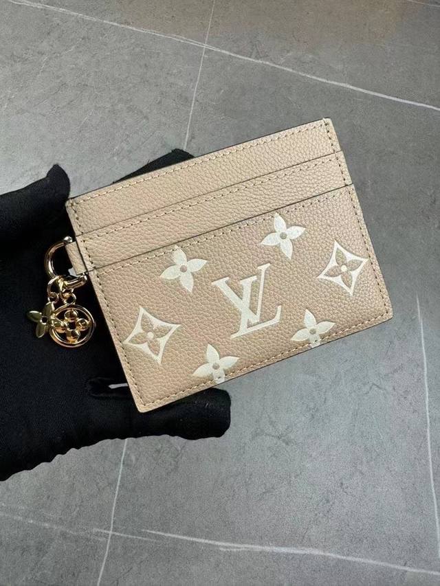 M82739 取材 Monogram 涂层帆布和牛皮革，为大号隔层两侧均衡配置卡片夹层。Monogram 花卉装饰散发莹泽光芒，成就赠礼佳选。尺寸：10.2 X