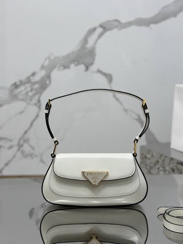 亮面翻盖单肩包 别致高贵亮面小牛皮 精致时尚全新锁扣开合 大Logo三角徽标完美融合于包身 配有2条肩带可拆卸可调节 既可以作为腋下包也可以调节成斜挎包 线条流