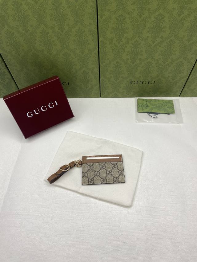 配红盒包装 Gg Emblem系列饰包带卡片夹 Gg Emblem系列以创意设计和创新功能焕新诠释经典图案，匠心缔造未来数年的珍藏之选。这款米色和深棕色卡片夹焕