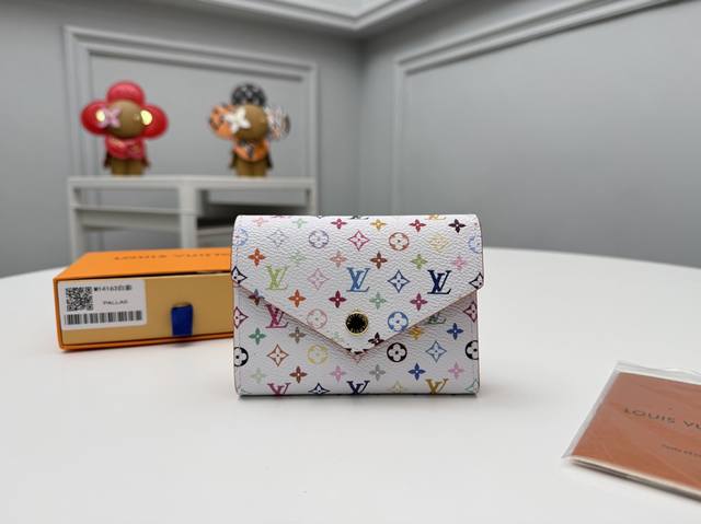 顶级原单 M14163白彩以生动的多色单体图案更新的紧凑型钱包“Lv×Tm波尔图 维克托里尼”。ルイヴィトン×村上隆”系列的重新发行，以象征这位日本艺术家的彩虹