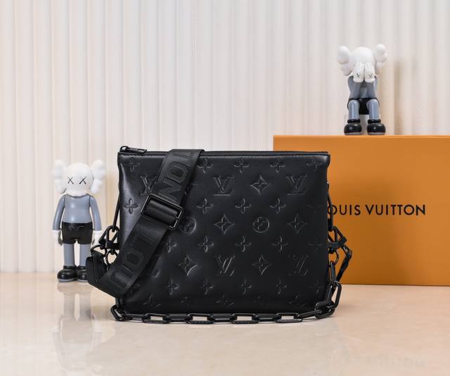 M57790 M21773 烤漆黑 由蓬松的 Monogram 压纹版羊皮革制成的 Coussin小号手袋，包内两个隔层之间配有拉链口袋。粗犷链条与织物宽包带均