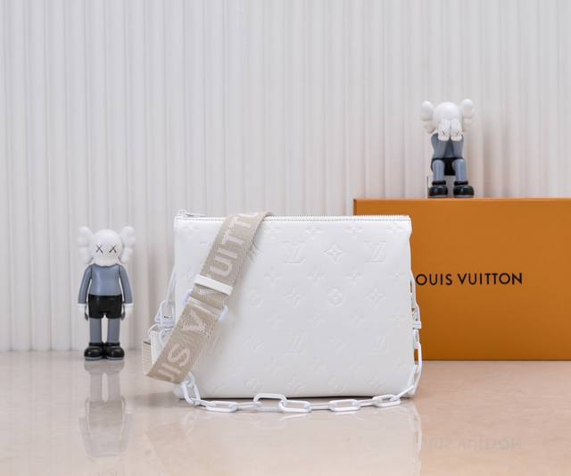 M57790 M21773 烤漆黑 由蓬松的 Monogram 压纹版羊皮革制成的 Coussin小号手袋，包内两个隔层之间配有拉链口袋。粗犷链条与织物宽包带均