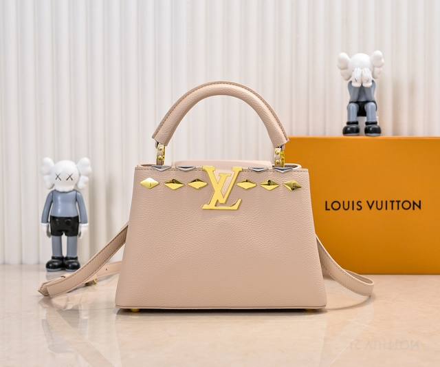 升级版 M12135杏色本款Capucinesbb手袋取材Taurillon牛皮革，以混合金属菱形Malletage元素装饰上缘，展现经典设计的华美演绎。翻盖提