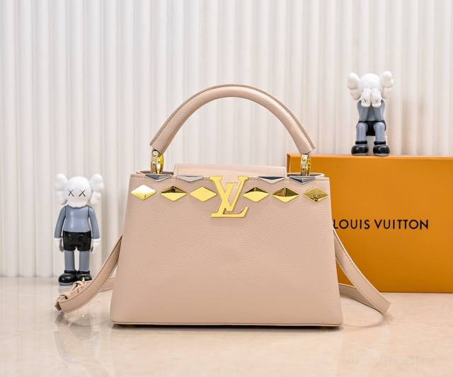 升级版 M12136杏色本款Capucines中号手袋向品牌经典硬箱汲取灵感，将标志性Malletage元素化为菱形金属装饰，与Taurillon牛皮革包身相得