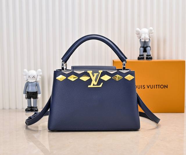 升级版 M12136蓝色本款Capucines中号手袋向品牌经典硬箱汲取灵感，将标志性Malletage元素化为菱形金属装饰，与Taurillon牛皮革包身相得