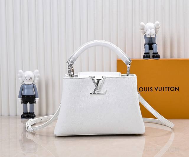 升级版 M85920白色 本款 Capucines Bb 手袋采用华美鳄鱼手腕和羊皮革内衬，以标志性构型和细节彰显 Capucines 系列的新古典主义风尚。无