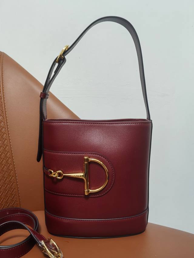 2025春夏系列 Gucci 73系列从与其系列名同年推出的一款典藏水桶包中撷取创作灵感。这款包袋以现代美学演绎马衔扣造型配件，可以斜挎、肩背，也可以作为手提包