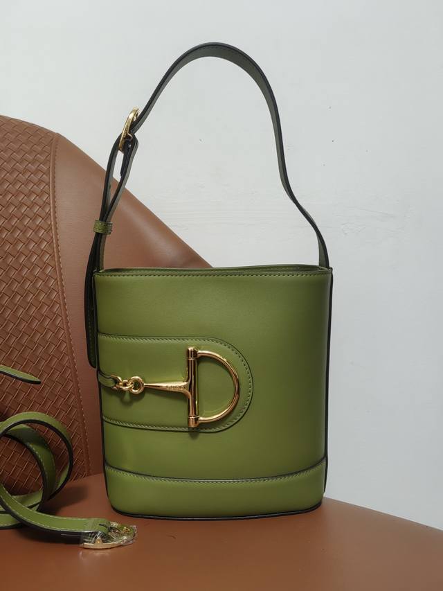 2025春夏系列 Gucci 73系列从与其系列名同年推出的一款典藏水桶包中撷取创作灵感。这款包袋以现代美学演绎马衔扣造型配件，可以斜挎、肩背，也可以作为手提包