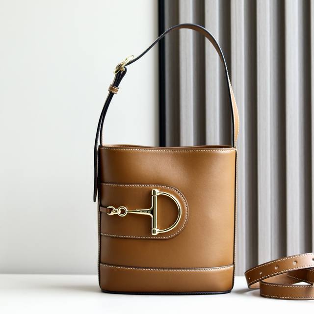 顶级原单 2025春夏系列 Gucci 73系列从与其系列名同年推出的一款典藏水桶包中撷取创作灵感。这款包袋以现代美学演绎马衔扣造型配件，可以斜挎、肩背，也可以