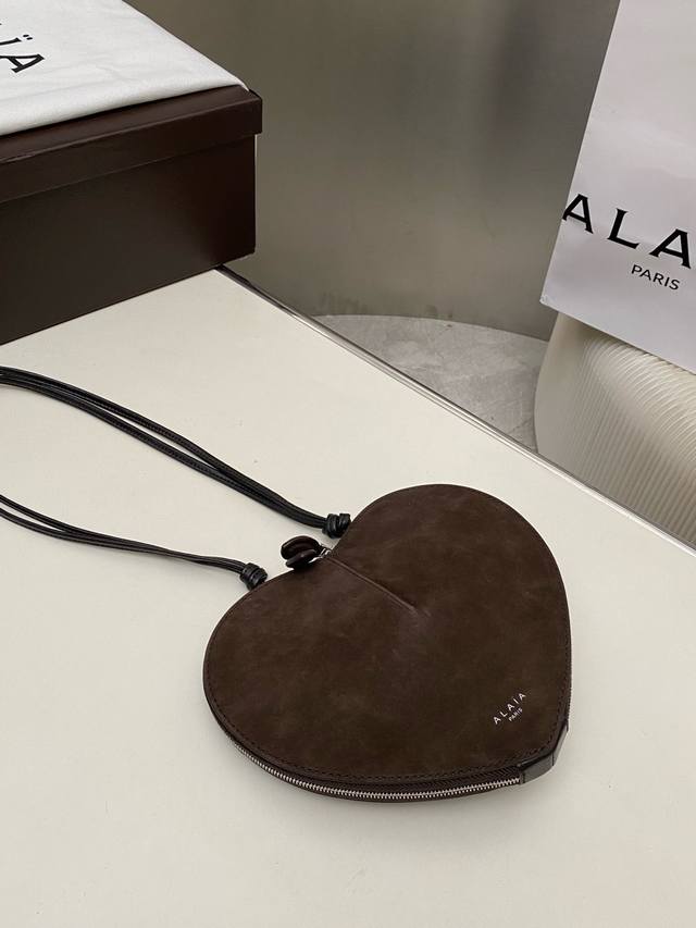 Alaia爱心包雕塑抛光小牛皮肩包。 可调节肩带采用打结设计正面印有徽标双向拉链封口 抛光皮衬里 H7.25英寸X宽8英寸Xd2英寸 供应商颜色：黑色 小牛皮。