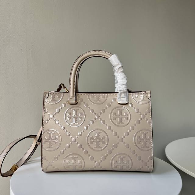 Tb新款、经典T Monogram 图案，搭配压花皮革。魅力隽永又风格独具。T Monogram 手提托特包，配有可拆卸斜挎背带。更以柔软纤细的绒面皮革打造包袋