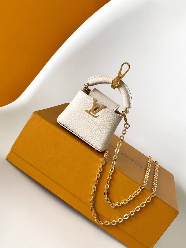 M02132 特级原厂皮 Micro Bag Capucines 包饰取材丰盈牛皮革，以金属 Lv 字母搭扣彰显华美格调，搭配 Monogram 花卉弹簧扣。袖