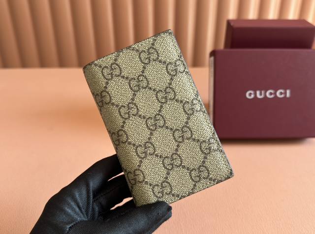 配置专柜全套包装 Gg Emblem系列以创意设计和创新功能焕新诠释经典图案，匠心缔造未来数年的珍藏之选。这款双折钱包以黑色全新Gg字母交织图案织物匠心打造，焕