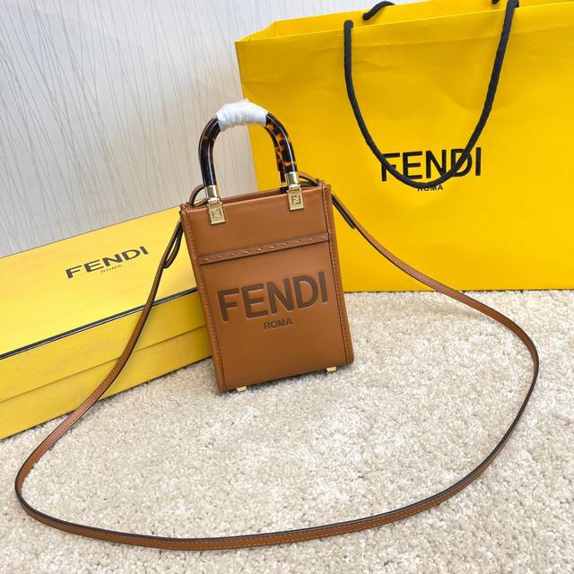 原单Sunshin棕色皮革迷你手提袋 饰有烫印Fendi Roma字样和玳瑁效果硬质有机玻璃提手 配备带衬里内部隔层 点缀同色系皮革饰边和金色金属件 采用两个提