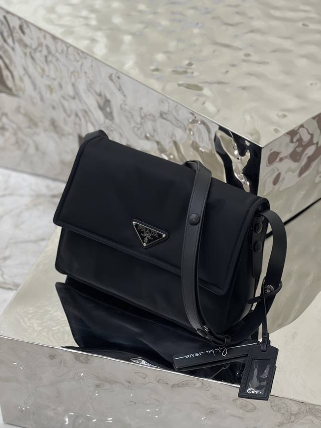 Cini系列邮差包 中号 这款单肩包甄独特加衬尼龙打造，并配有皮革肩带和背面口袋，金属配件赋予一抹亮色，整体低调奢华又百搭，唯一不同之处不可拆卸，设计更为简约，