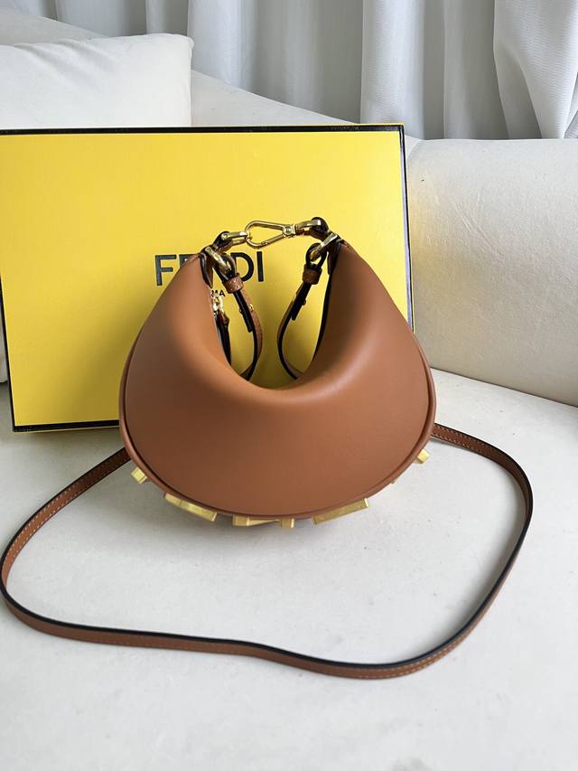 棕色 新尺寸小号Praphy腋下包，以月牙造型为特色，把经典金属大Logo[Fend1]装饰在包包底部，包包的轮廓很贴切身体的线条，背在腋下的时候时尚感满满，简