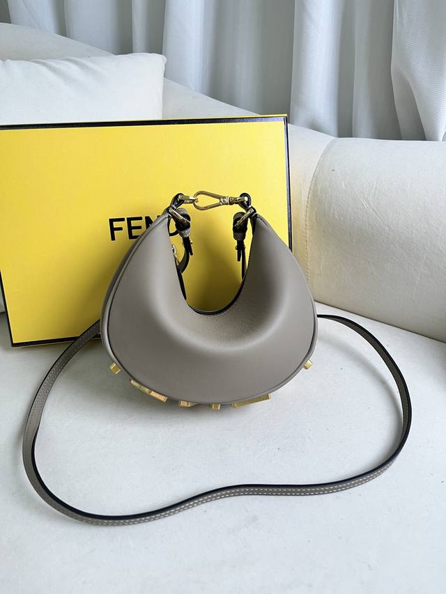 灰色 新尺寸小号Praphy腋下包，以月牙造型为特色，把经典金属大Logo[Fend1]装饰在包包底部，包包的轮廓很贴切身体的线条，背在腋下的时候时尚感满满，简
