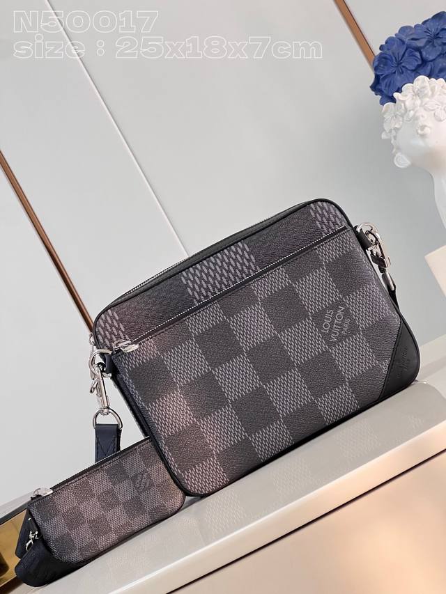 N50017 本款 Trio 邮差包以 Damier Graphite 3D 帆布的瞩目质感塑造功能性设计，可拆卸拉链前袋和零钱袋轻松收纳日常所需，可调节肩带确
