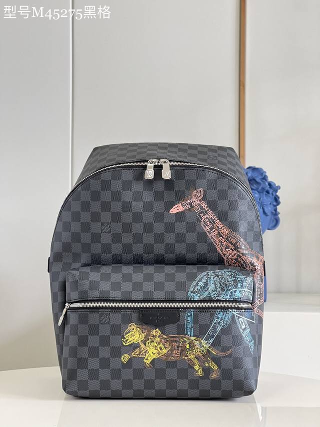 M45275 黑格 本款 Discovery 双肩包取材 Damier Graphite 帆布，以护照印章风格描绘野生动物形象，讲述长颈鹿、大象和老虎的迁徙故事