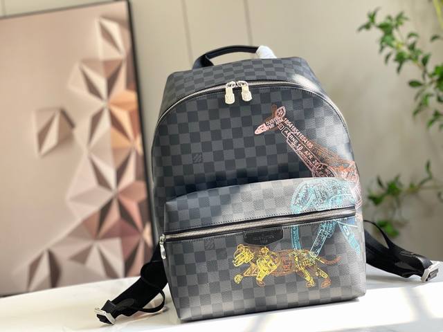 顶级原单45275本款 Discovery 双肩包取材 Damier Graphite 帆布，以护照印章风格描绘野生动物形象，讲述长颈鹿、大象和老虎的迁徙故事。