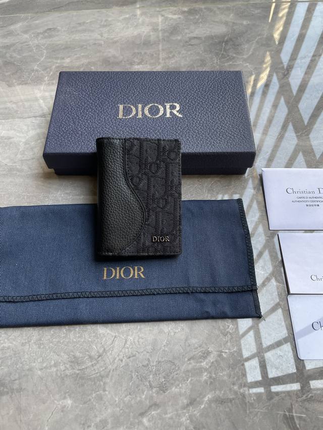 马鞍竖版双折卡夹 黑色细工镶嵌粒面牛皮革搭配黑色Oblique 印花 编号:2Adch169Yks_H03E 尺寸：8.2×11.2.Cm这款马鞍竖版双折卡夹是