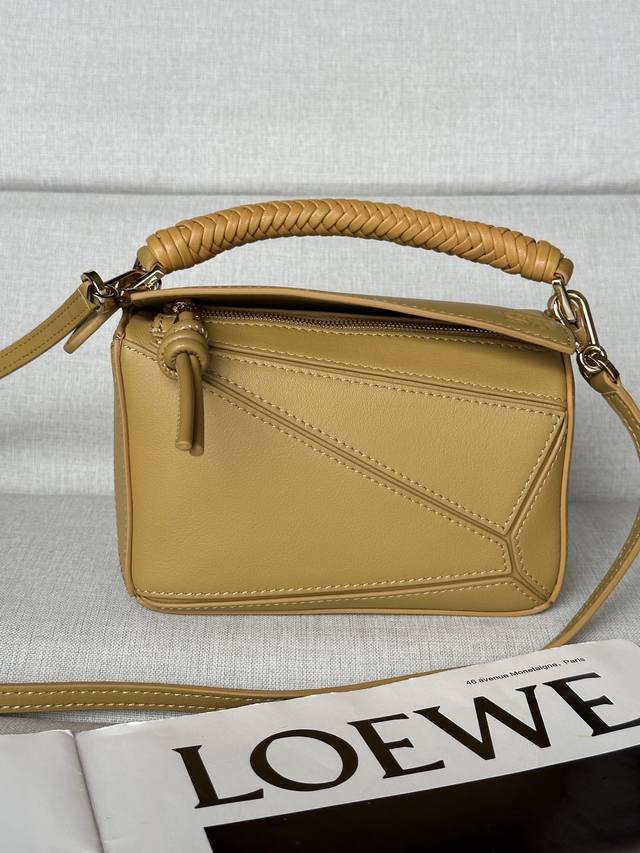 原厂皮 迷你光滑牛皮革 Puzzle 手袋 Puzzle 以别具一格的几何线条勾勒长方体造型。此迷你版本采用光滑牛皮革制成，配有编织纳帕羊皮革提手和绳结拉链头。