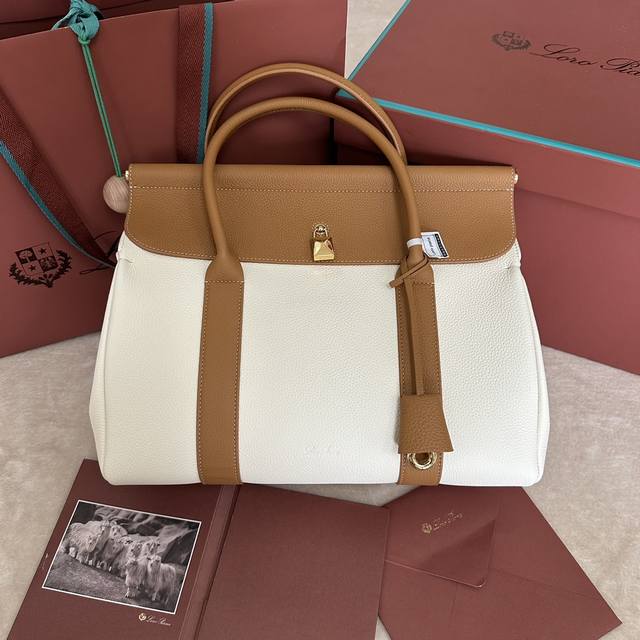 Loro Piana Loom L32手袋 颜色：白色配棕 Loom手袋向Loro Piana悠久的纺织传统致意，翻盖下方的金属条让人不禁联想起布料从工匠的织机