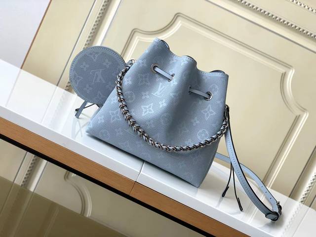 海原外单 独实家拍 原版开发，此款配有零钱包的 Bella 水桶包由 Mahina 牛皮革制成，平纹 Lv 与 Monogram 花卉图案周围环绕 60,000