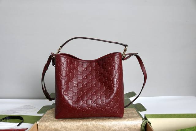 跑价量 简介：Gg Emblem系列焕新诠释品牌的隽永优雅风范和精湛工艺。这款水桶包采用织带棉质衬里，设有一个内部隔层，实用性出众。 黑色Gg印花压纹皮革 浅金