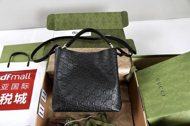 跑价量 简介：Gg Emblem系列焕新诠释品牌的隽永优雅风范和精湛工艺。这款水桶包采用织带棉质衬里，设有一个内部隔层，实用性出众。 黑色Gg印花压纹皮革 浅金