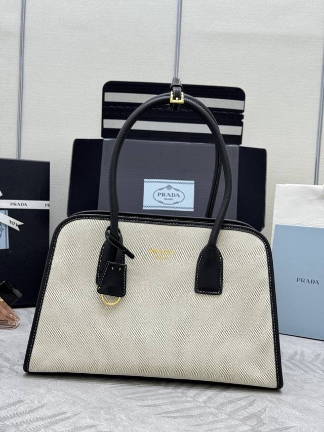 新款亚麻布托特包1Bg572 这款包袋结合牛皮与亚麻混纺面料的百搭风尚与轻盈质感，塑就Oversize廓形，巧妙演绎二元性。功能实用，设计精致，精湛细节彰显P家