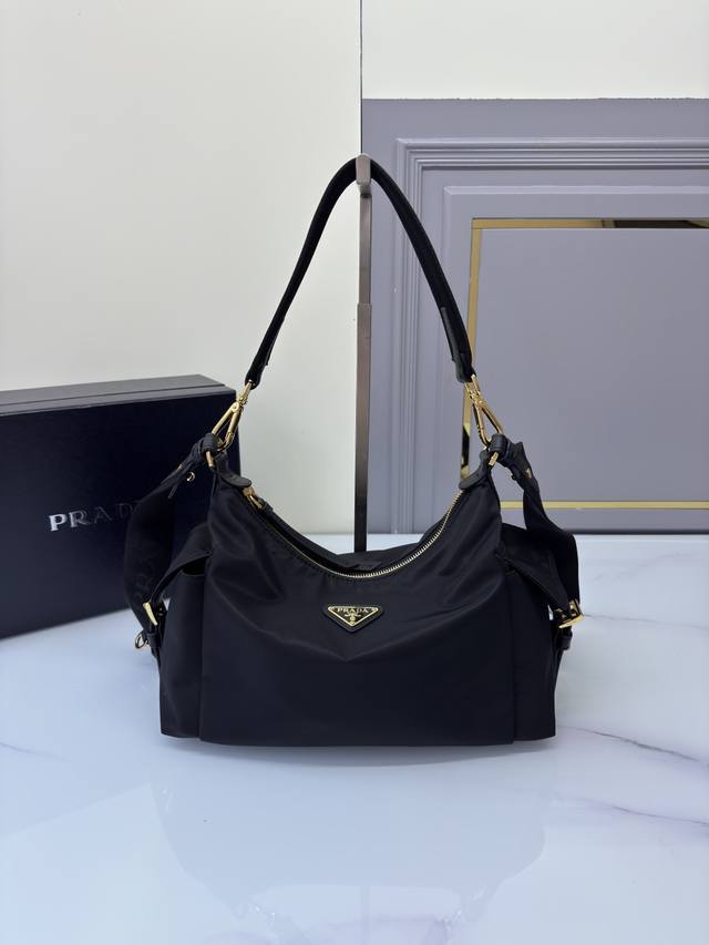 新品1Bc264探索包 这款探索包采用进口尼龙面料和小牛皮，具有柔软的轮廓和多个口袋。轻质实用的Re-Nylon强调了设计的多功能风格，而皮革细节和标志性点缀则